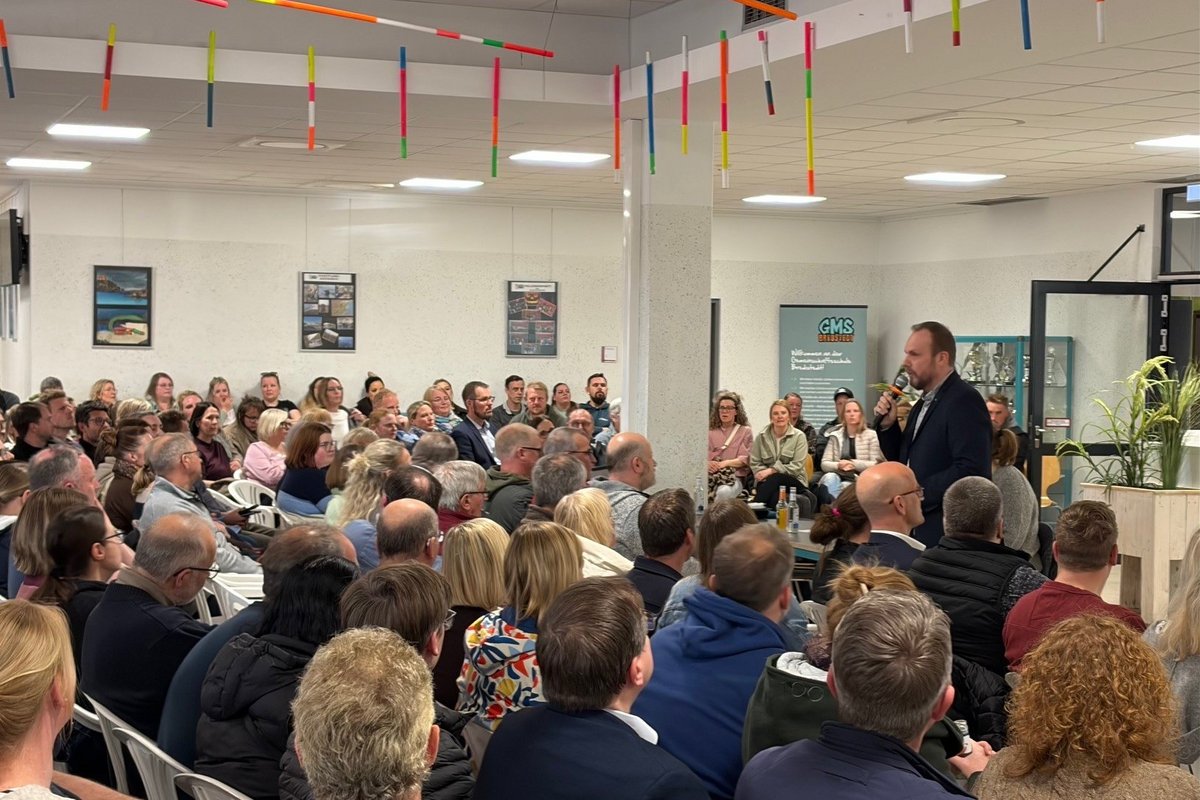 Verbandsvorsteher Ralph Ettrich informierte rund 300 Interessierte zur Schulentwicklung im Mittleren Nordfriesland. Foto: Felix Middendorf ein Mann steht vor vielen sitzenden Menschen und spricht