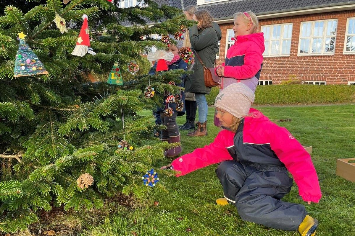 Ein kleines Mädchen vor einem Tannenbaum