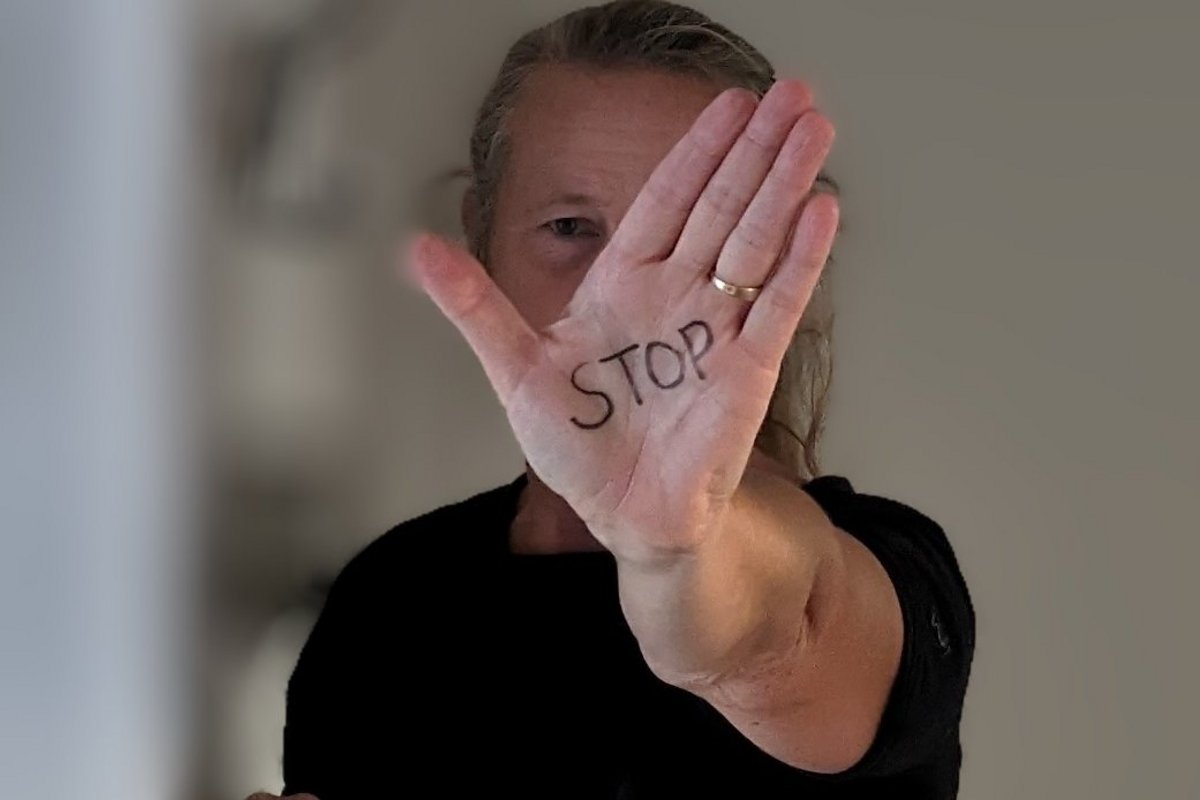 Eine ausdrucksstarke Körpersprache zählt zu den wichtigen Elementen des Trainings. Foto: AMNF eine Frau signalisiert mit ausgestreckter Hand: Stopp!