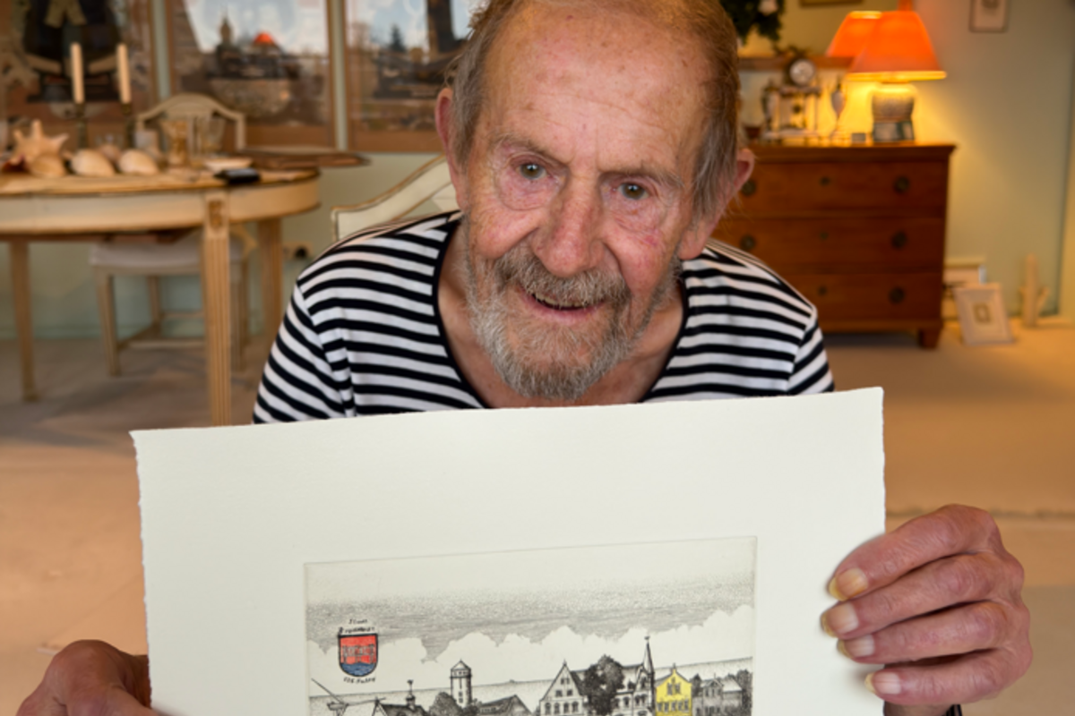 Peter Froese mit seinem letzten Bredstedt-Motiv zu 125 Jahren Stadtrechte. Foto: Christian Schmidt Ein Mann hält ein Bild in Händen auf dem Häuser zu sehen sind